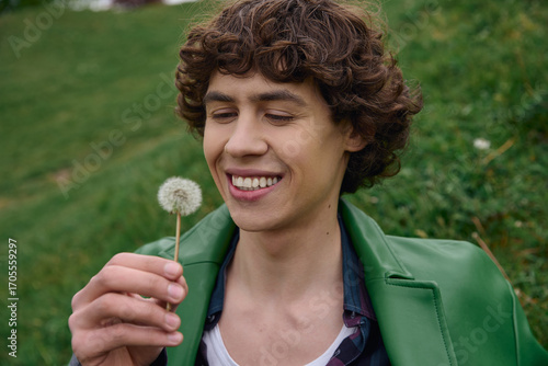 Papier peint Young student enjoys a peaceful stroll outdoors while admiring a dandelion bloom