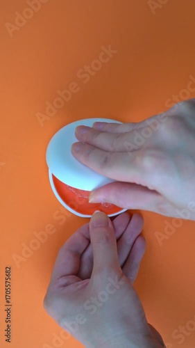  Opening White and Orange Dental Aligner Case that are Orthodontic Mouthpiece storage in orange background. Slow motion. vertical video.