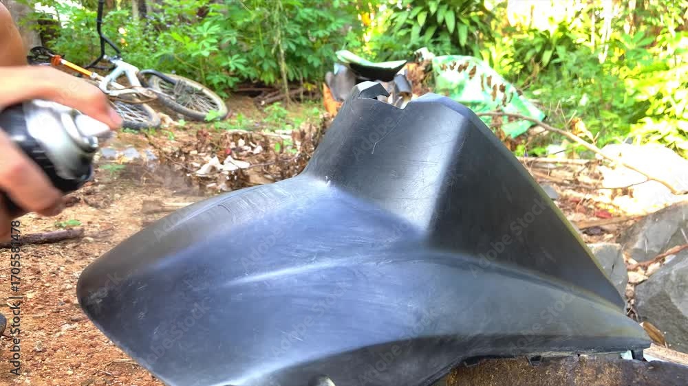 Man Painting Motorcycle Body with Aerosol Spray Paint