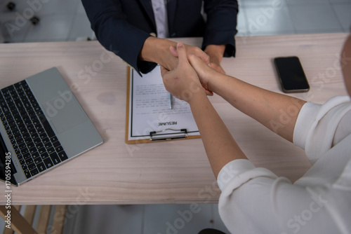 Businesswomen shaking hands after successful job interview and resume review