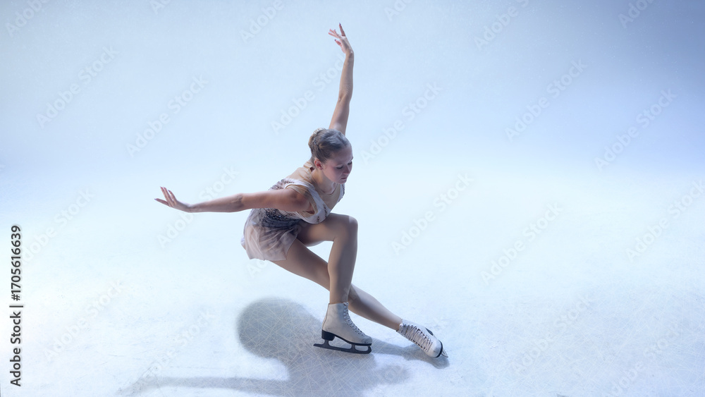 Fototapeta premium Figure skater bending low in dynamic choreographic move on white ice. Concept of fitness power, movement art, editorial performance, and lifestyle inspiration.