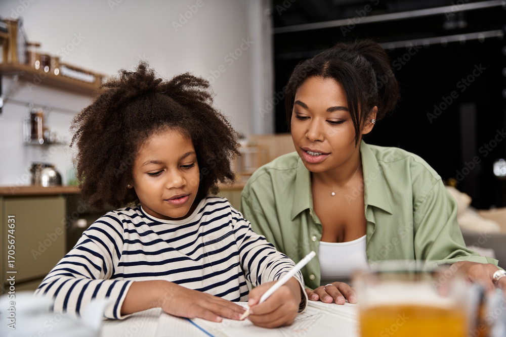 Obraz premium Mother and daughter sharing a creative moment at home together in a cozy environment