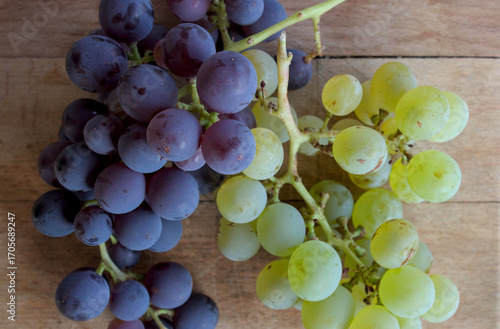 White and black grapes on a wooden cutting board