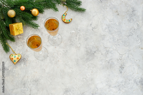 Christmas decoration top view - fir tree branch and two glasses of champagne. Festive flat table setting