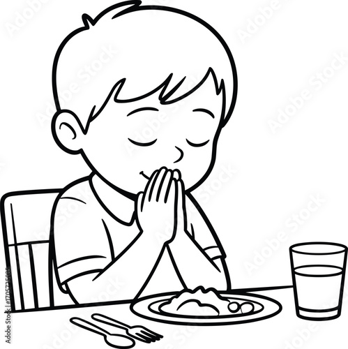 Young boy praying before eating, child giving thanks at meal table, faith-based habit, religious practice, family values, mealtime gratitude, black and white