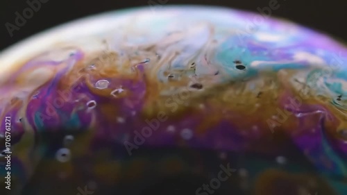 Close-up view of a colorful soap bubble, displaying iridescent patterns and textures.