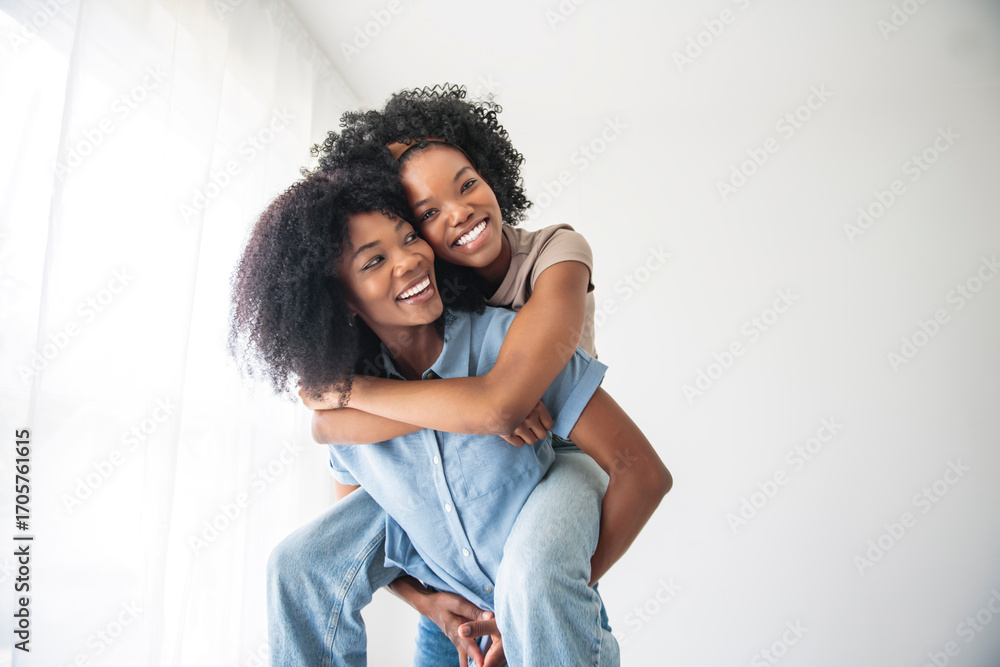 Obraz premium Affectionate mother and daughter portrait close to a white wall