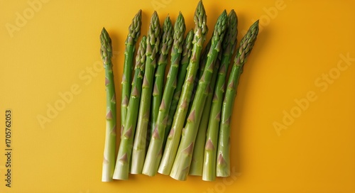Fresh Asparagus Arranged on a Vibrant Yellow Background Ready for a Healthy M...