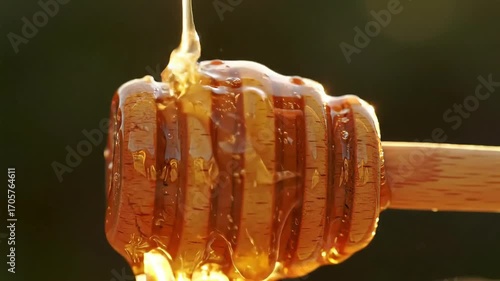 Honey dripping from a wooden honey dipper, close-up shot.