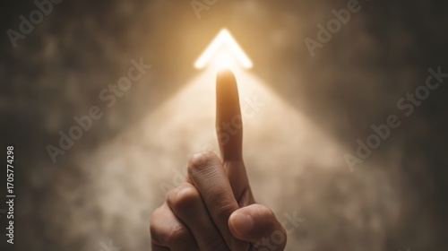 A person's left hand points upwards with a glowing index finger against a textured background emitting soft golden light