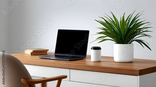 A clean and organized desk workspace featuring a laptop computer, a potted plant, and a coffee mug, creating a simple and efficient work environment.