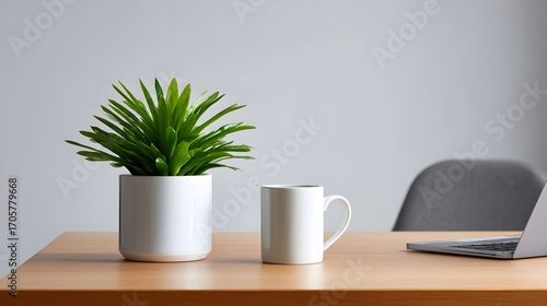 A simple and organized minimalist workspace featuring a green potted succulent plant, a ceramic coffee mug, and a laptop computer on a wooden desk, creating a calming and focused environment.