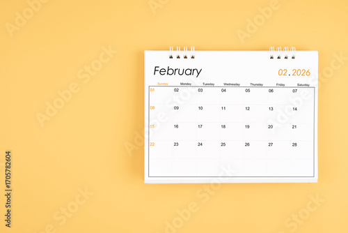 February 2026 desk calendar on yellow color background, position with copy space.