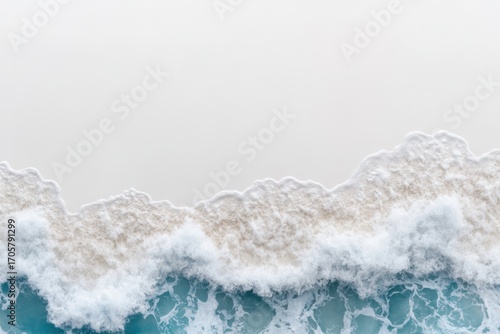 Azure Embrace: An aerial view captures the raw power and beauty of the ocean's embrace, where cerulean waves delicately caress the sandy shore. Evoking a sense of serenity, tranquility.