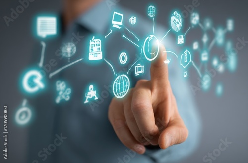 Finger activating digital icons; light emanates from the focal point. The soft background is neutral, and the subject is an arm extending toward the viewer