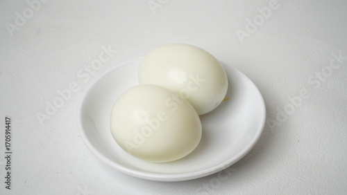 Photos Peeled boiled eggs served on a white plate with a white background