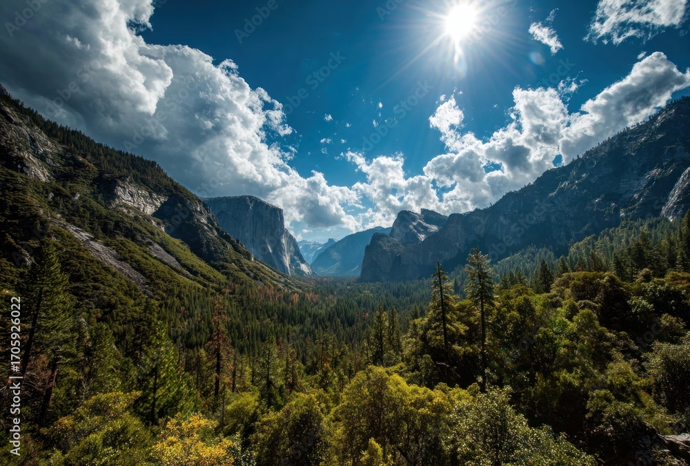 Fototapeta premium A sun-drenched valley vista featuring tall trees, jagged cliffs, and scattered clouds under a bright sun in a rich blue sky