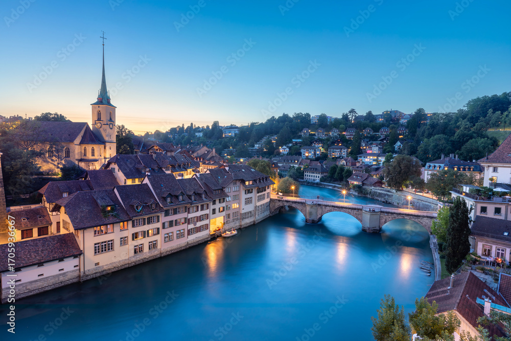 Fototapeta premium Bern, Switzerland. View of stone arch Untertorbrucke (Lower Gate Bridge) and Aare river at dusk