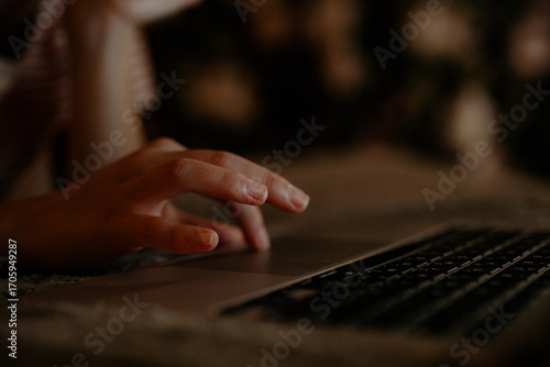 Fotografi A person is using a laptop late at night, illuminated by soft light