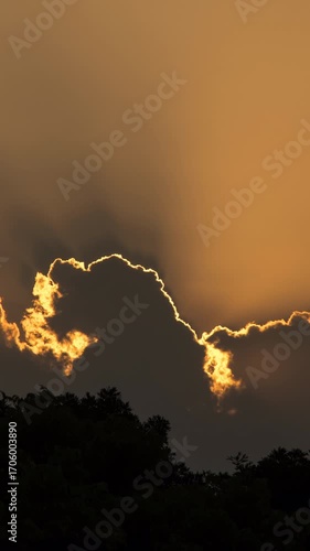 Vertical video - Timelapse of the sun setting behind the silhouette of the clouds
