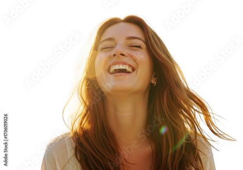 Joyful young woman with flowing auburn hair laughing with eyes closed and sunlight glinting transparent background