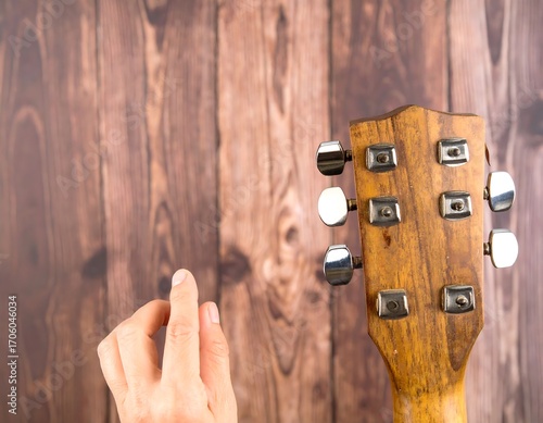 Hand near acoustic guitar headstock