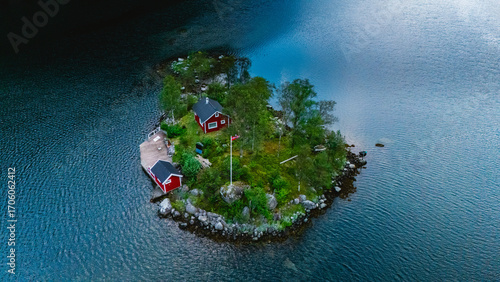 Obraz na plátně Nestled in Lovrafjorden, this charming island features traditional red cabins amidst vibrant nature