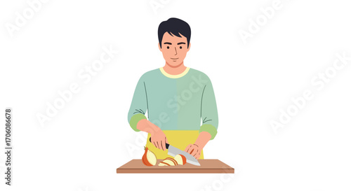 Young man in a yellow apron slicing a fresh onion on a wooden cutting board.