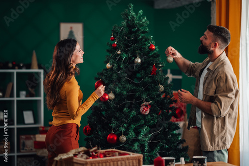 Canvas Print Couple decorating christmas tree at home together