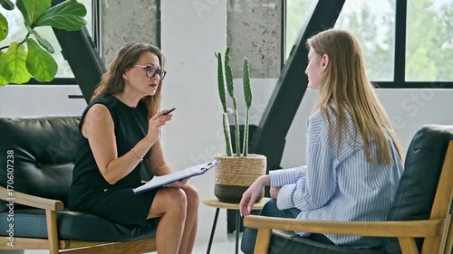 Female professional mental specialist, therapist working with patient young woman in office