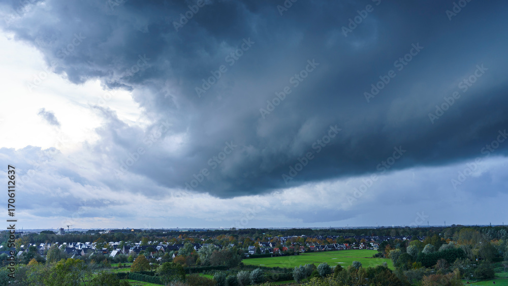 Fototapeta premium Breathtaking balcony view overlooking the lush green fields of Holland's countryside during a stormy summer sunset near Amsterdam, Netherlands