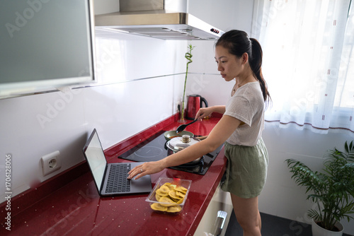 Woman cooking in a modern kitchen setting at home