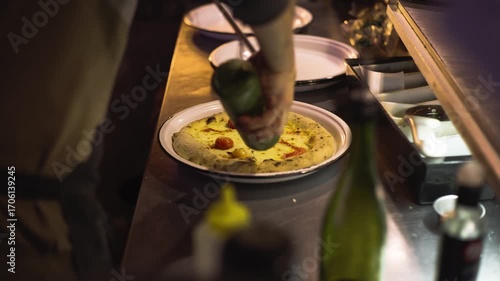 Wood-fired oven with sourdough pizzas in a restaurant at night in Buenos Aires, chefs cooking, warm lights and busy kitchen atmosphere.