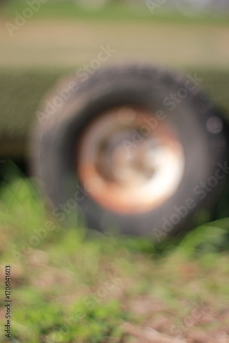 A soft focus view of a wheel in the grass.