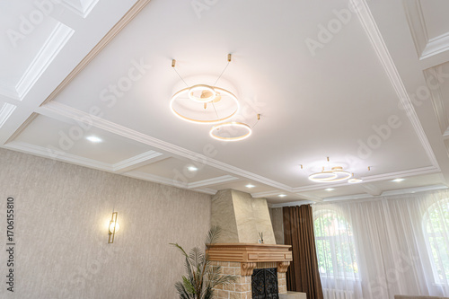 Cuadro en lienzo Elegant interior featuring a white coffered ceiling with modern ring chandeliers