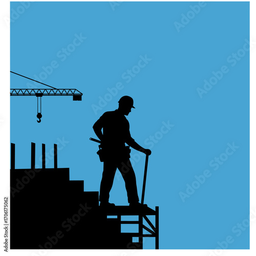 Silhouette of a construction worker standing on scaffolding against a clear blue sky with a crane in the background