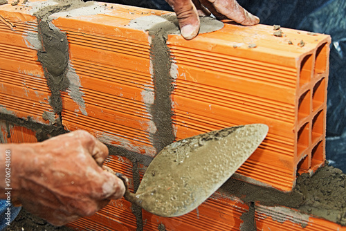 Bricklayer raising a brick wall by mason, Brasilia, Brazil, Sep. 2020