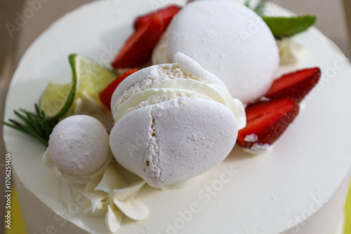 Cuadro en lienzo A close-up of a white cake decorated with fresh strawberry pieces, white meringue, and lime slices, creating a sense of freshness and sophistication