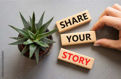 Share your story symbol. Wooden blocks with words Share your story. Beautiful grey background with succulent plant. Businessman hand. Business and Share your story concept. Copy space.