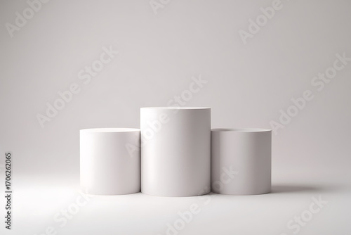 Three white cylinders on a white background, representing a podium