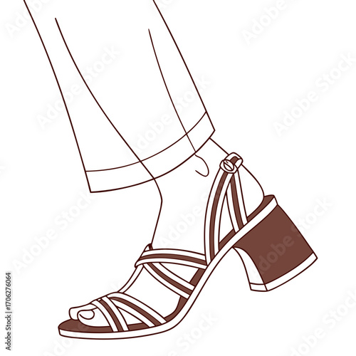 Fashionable woman s foot wearing a stylish brown strappy block heel sandal with a buckle and elegant trousers for a chic summer look