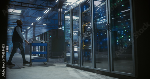 Wide view of technician walking through data center.