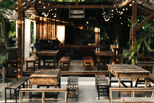 Photos outdoor seating area with vintage wooden tables and benches under natural light,