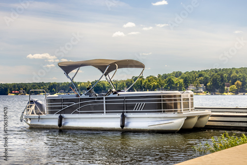 Pontoon boat at private marina dock on freshwater lake.