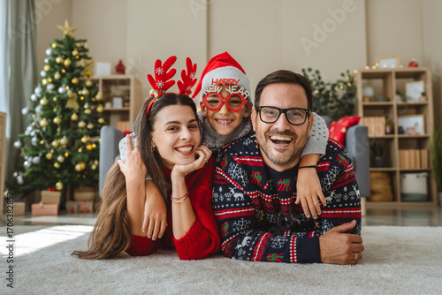 Happy family lying down celebrating christmas at home