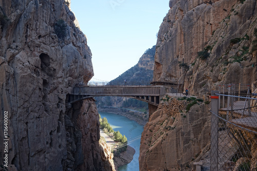 Breathtaking view of the Caminito del Rey walkway suspended between steep rocky cliffs over the El Chorro gorge and Guadalhorce river in Malaga, Spain