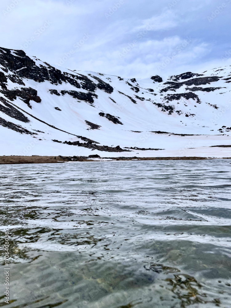 Obraz premium Stunning Landscape of Snow-Covered Mountains and Frozen Lake in Sierra Nevada, Spain - Scenic Winter View of Rugged Peaks and Icy Waters