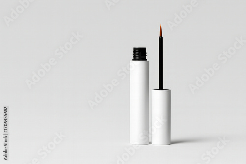 Eyelash growth serum with brush on a flat white background. White minimalist bottle, cosmetic product for eyelash care, isolated, perfect for advertising and design.