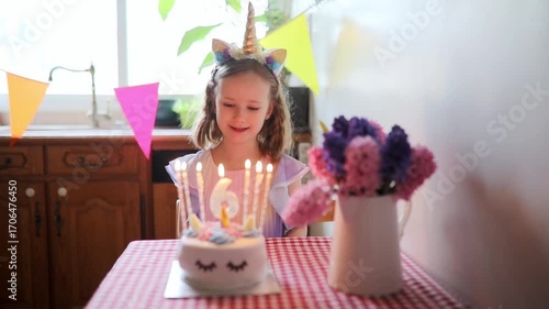 Happy little girl with unicorn hair decoration celebrating her sixth birthday