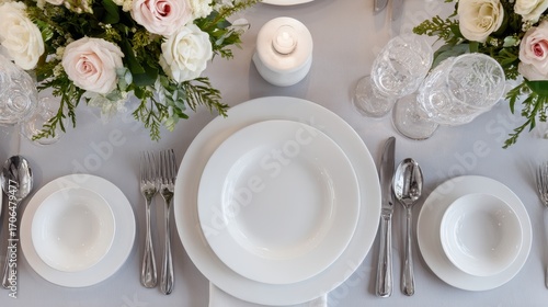 Elegant White Wedding Table Setting - Overhead View of Fine China, Silverware, and Floral Centerpiece.
